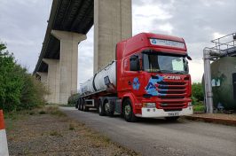 Red Scania AA Turner Tankers lorry driving under an underpass.